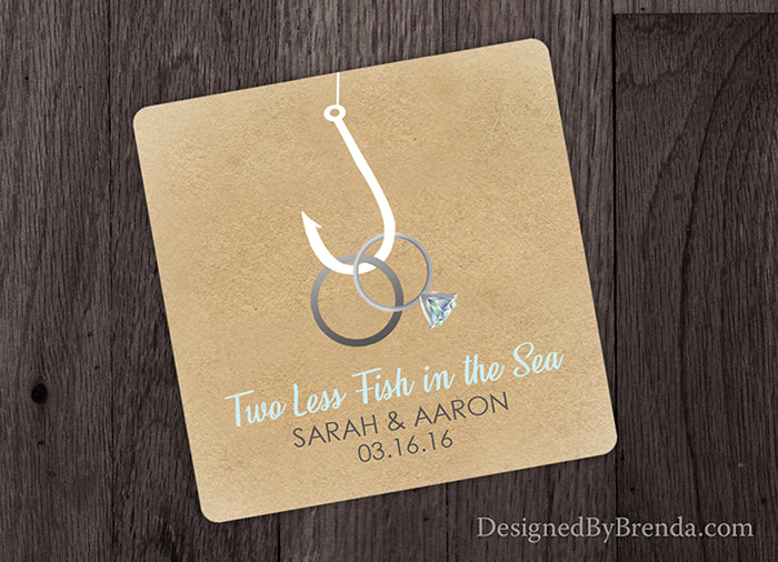 Two Less Fish in the Sea Paper Coaster Wedding Favor - Rings on Hook on Rustic Sandy Background